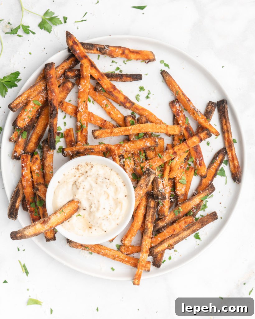 crispy oven baked yam fries are topped with finely shredded parmesan cheese and served with a flavorful homemade truffle lemon aioli