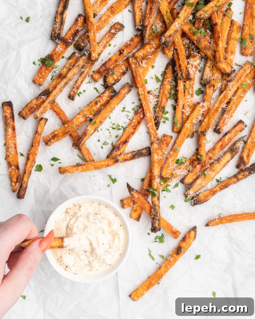 crispy oven baked yam fries are topped with finely shredded parmesan cheese and served with a flavorful homemade truffle lemon aioli