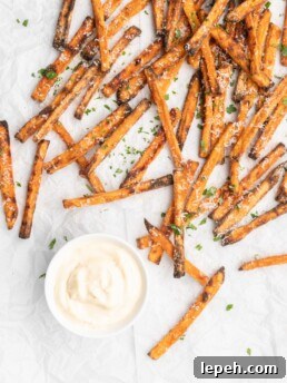 crispy oven baked yam fries are topped with finely shredded parmesan cheese and served with a flavorful homemade truffle lemon aioli