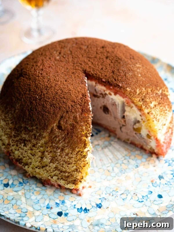 A dome shaped Italian dessert called Zuccotto on a patterned plate with a slice cut out.