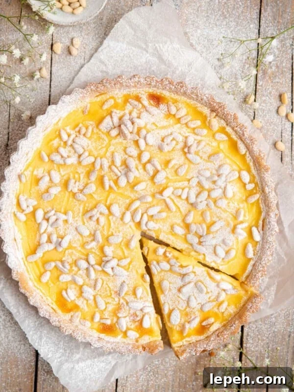 An overhead shot of torta della nonna on a rustic wooden surface