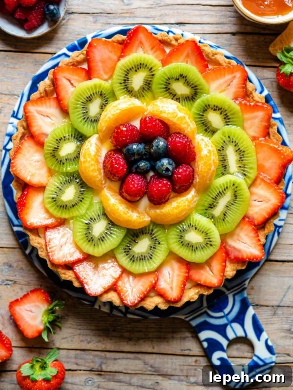 An overhead shot of a fruit tart layered with fresh fruit