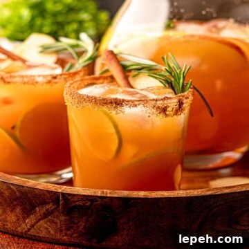 Apple cider margaritas garnished with rosemary and cinnamon sticks.