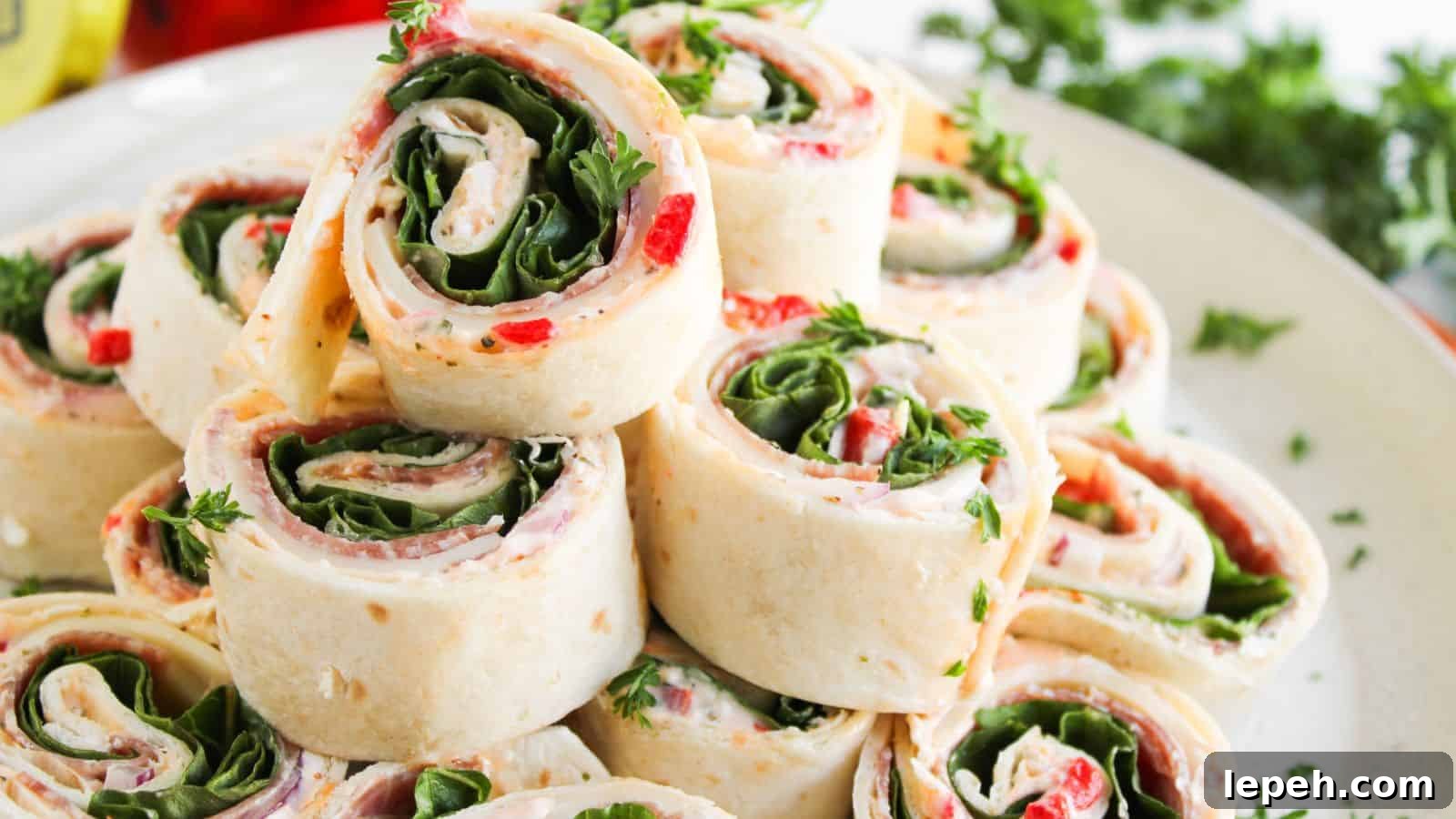 A plate of tortilla pinwheel sandwiches filled with spinach, cream cheese, red peppers, and herbs, neatly stacked and garnished with parsley.