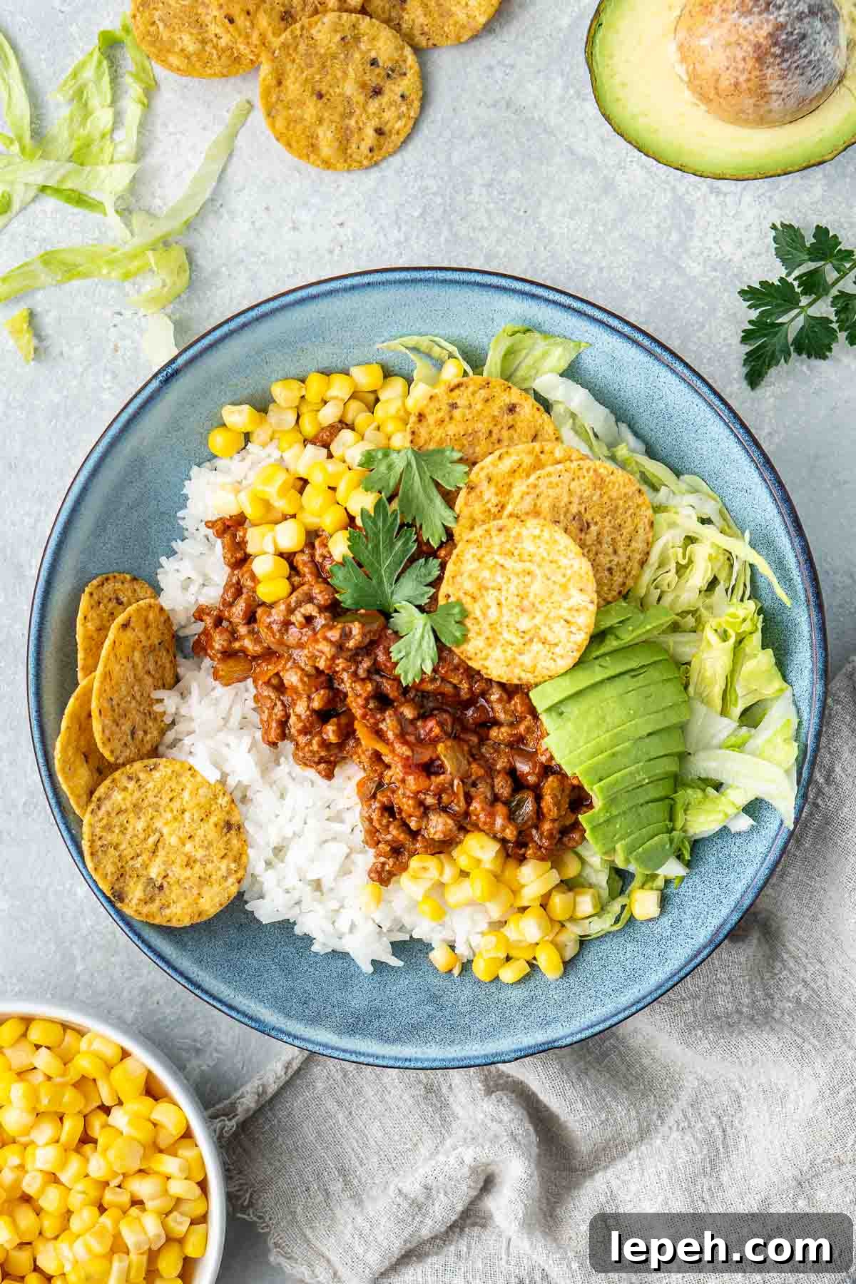 Taco bowls with avocado, rice and corn chips.