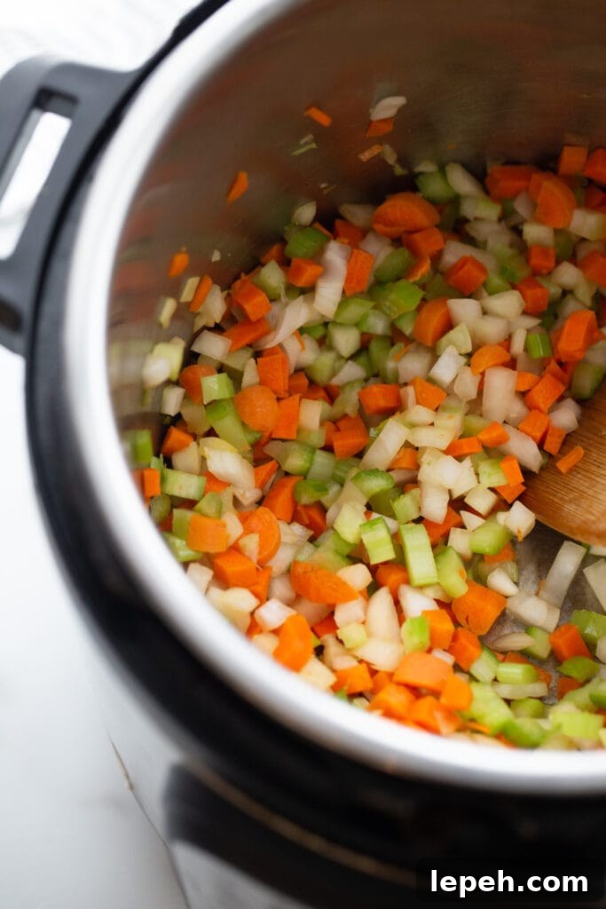 Overhead photo of chopped carrots, celery, and onion in an instant pot.