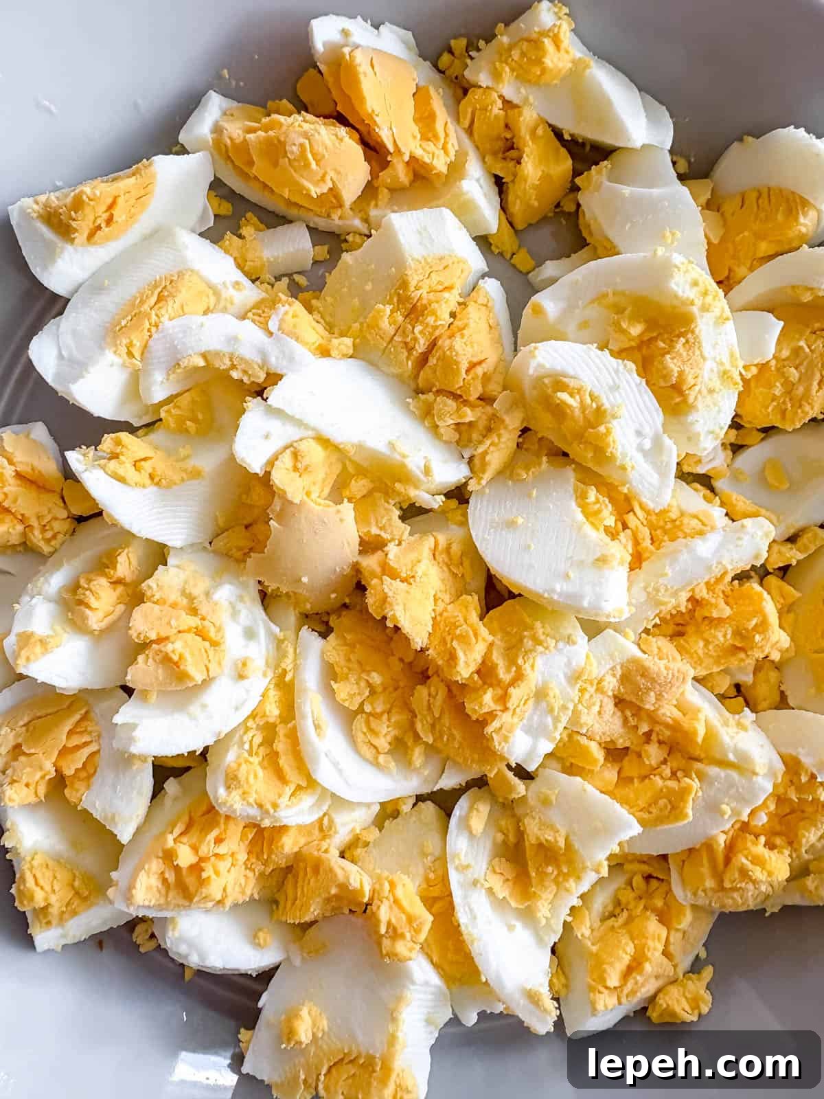 Hard boiled eggs cut up in a bowl.
