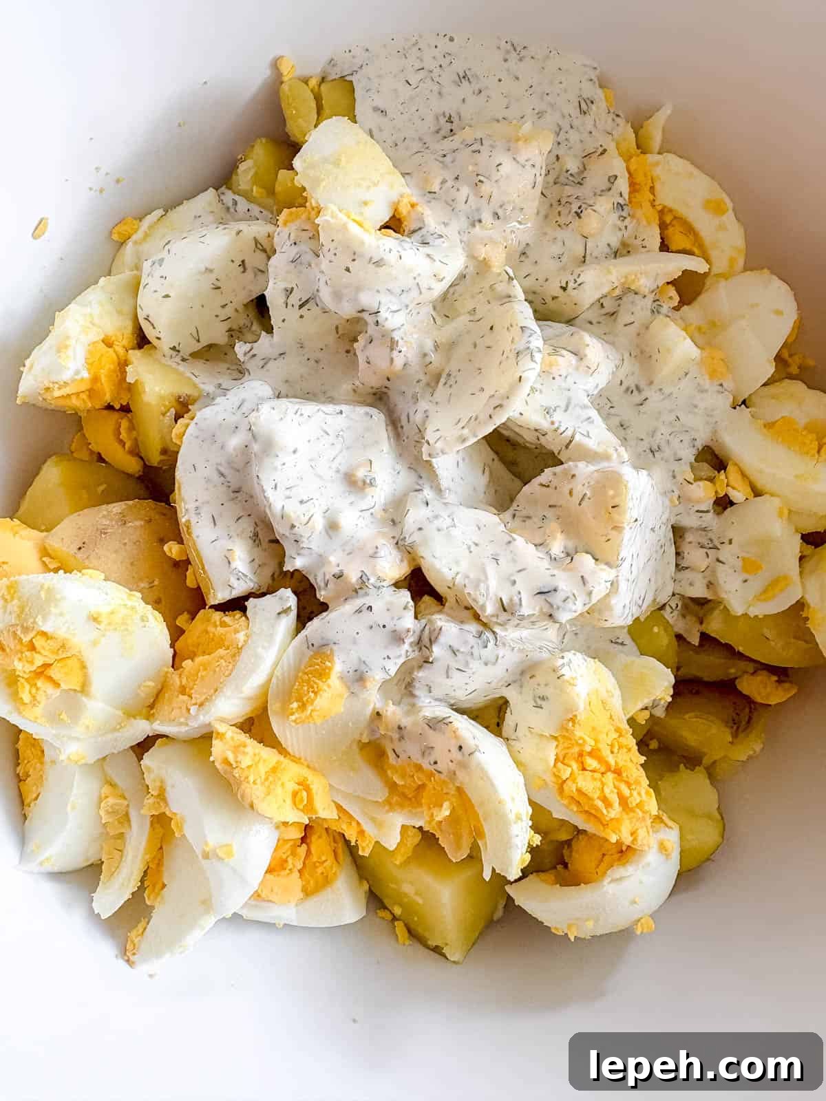All parts of the potato salad in a bowl before getting mixed.