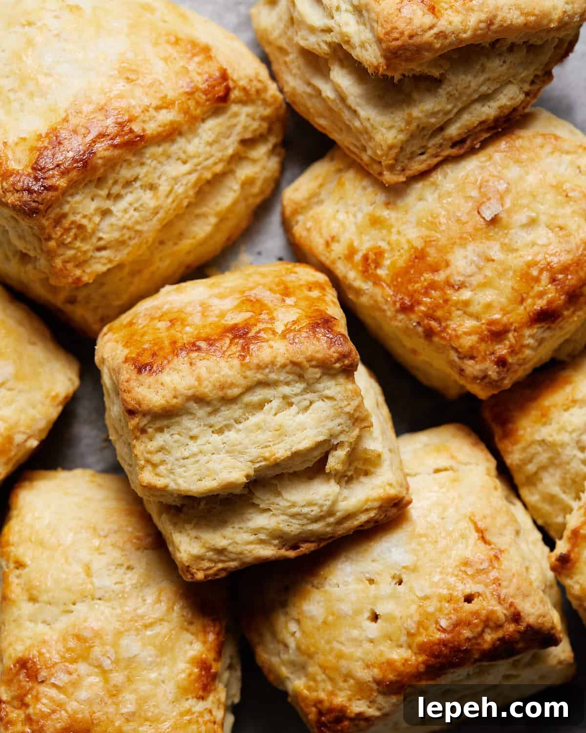 Easy homemade biscuits stacked up on baking sheet.