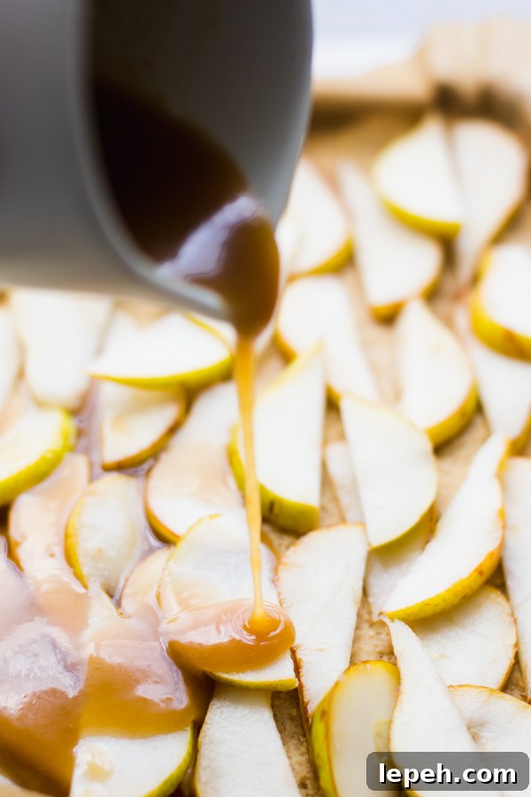Caramel sauce pouring over sliced pears.