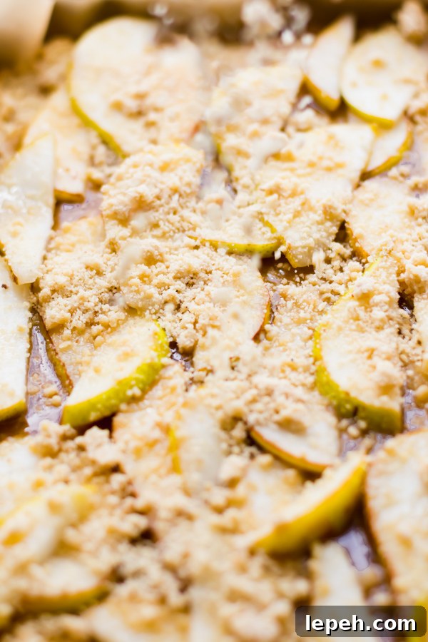 Crumble topping over sliced pears.
