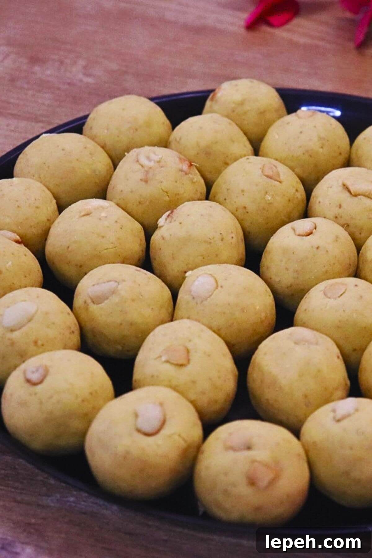 danedar besan ladoo served in a black colored plate.