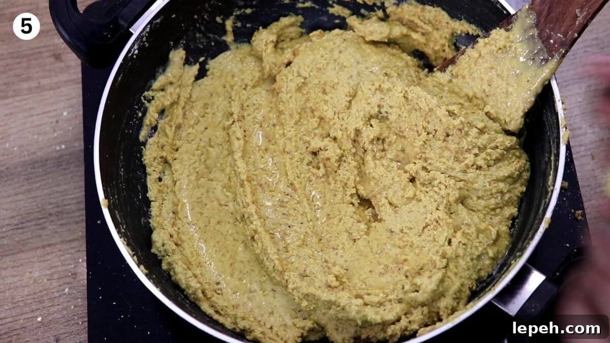 sprinkle some water over the roasted besan to make danedar halwai style besan ladoo.