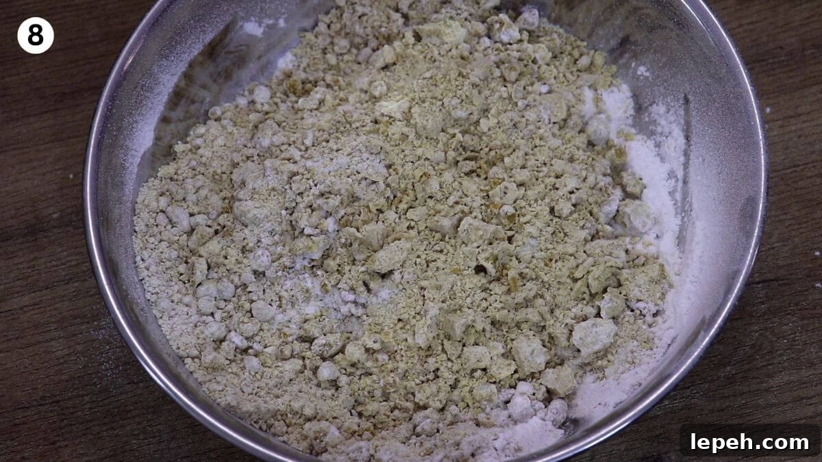 addition of boora and cardamom powder to roasted besan to make ladoo.