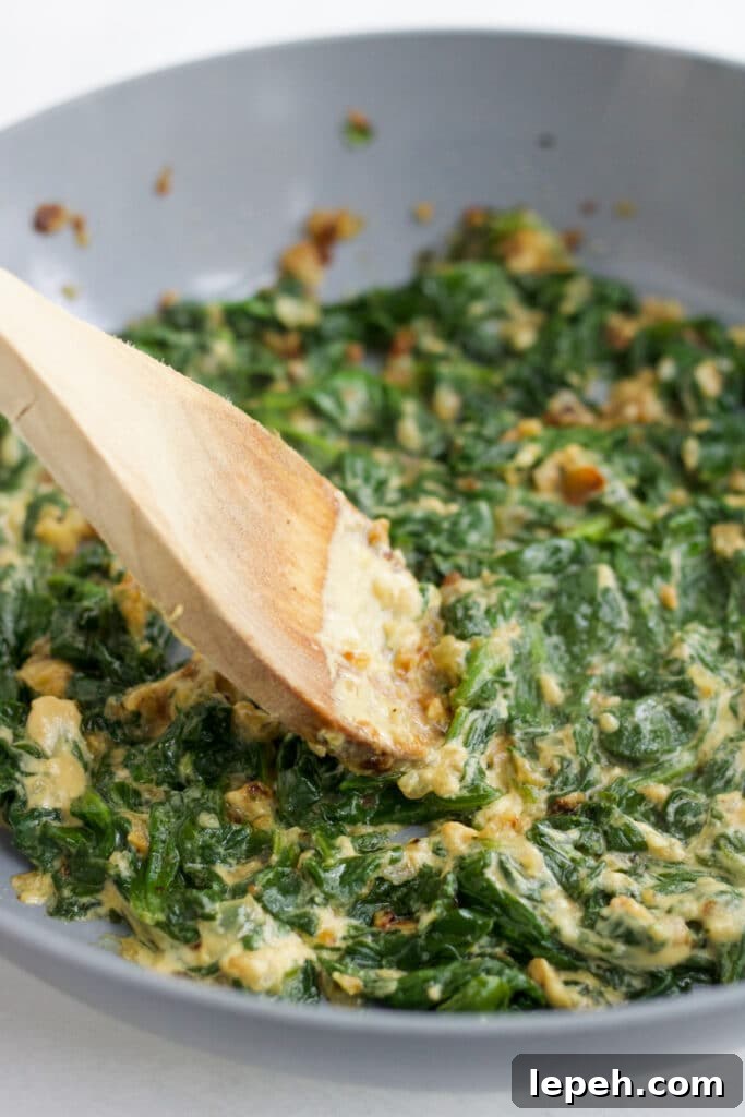 Cooking the spinach filling for pork wellington.