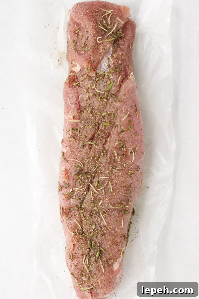 Pork tenderloin with meat rub spread all over it.