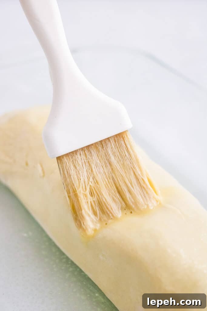 Brushing egg wash onto pork wellington.