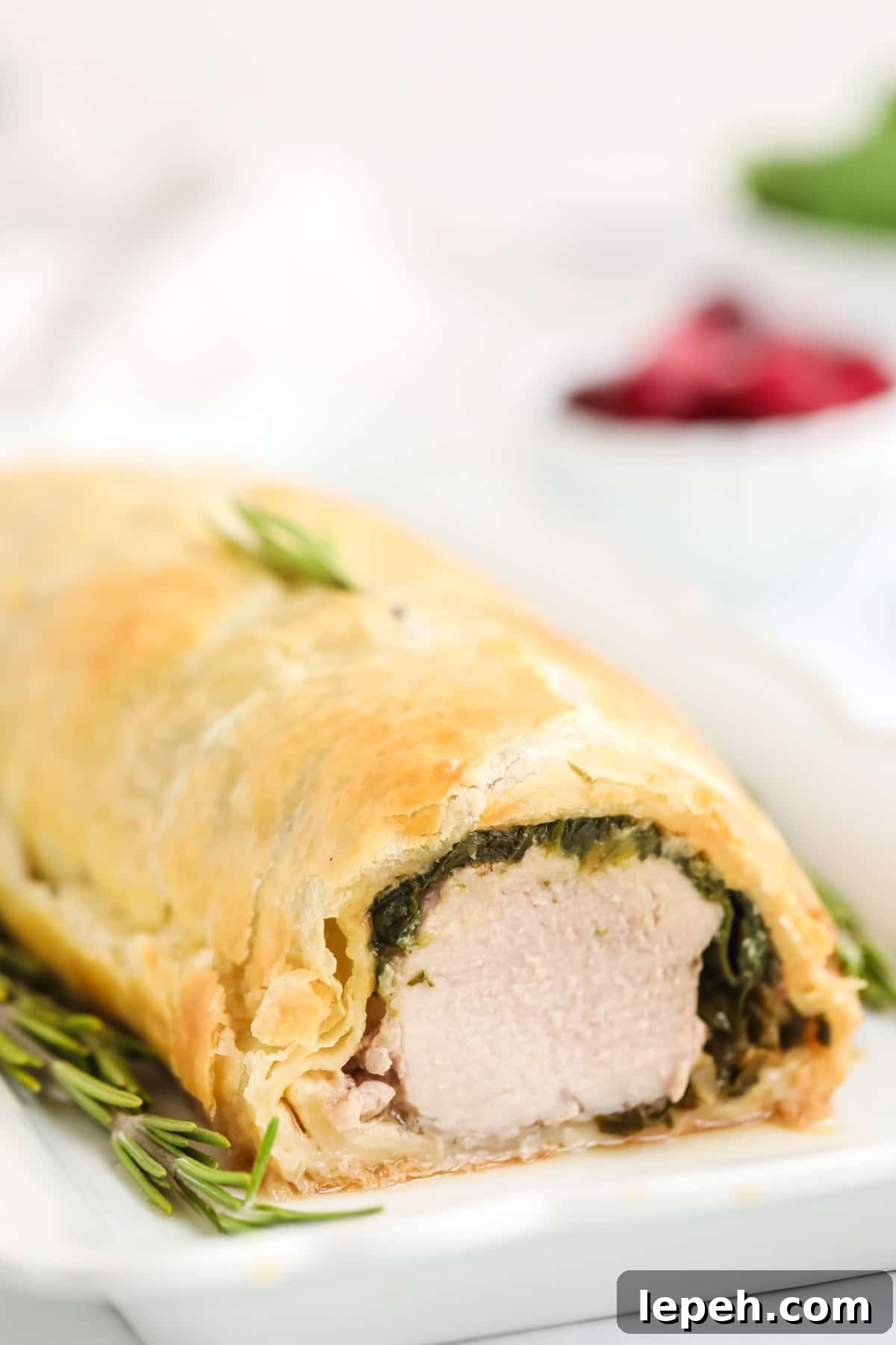 Pork wellington on a plate is served up on the table.