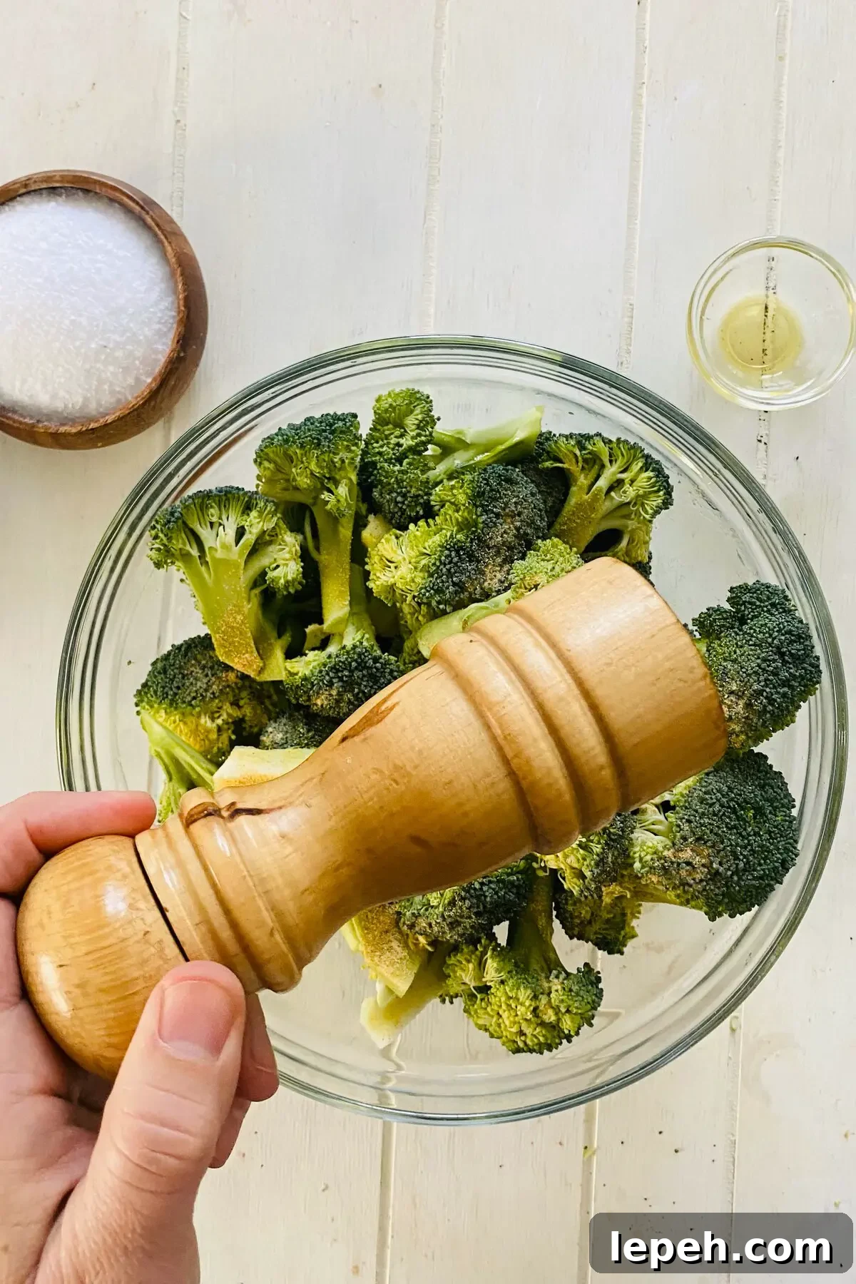 a peppermill and raw broccoli.