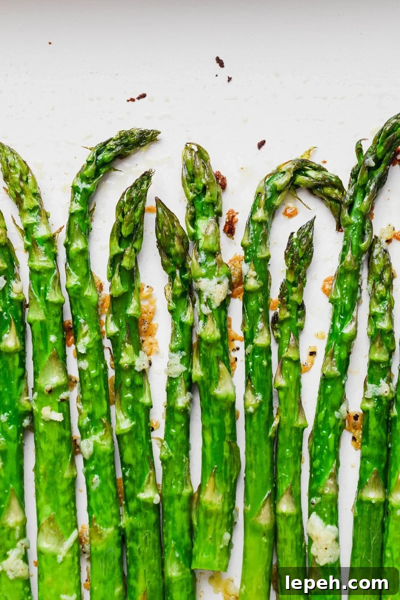 Overhead super close up image of crispy oven roasted asparagus with lots of garlic. 