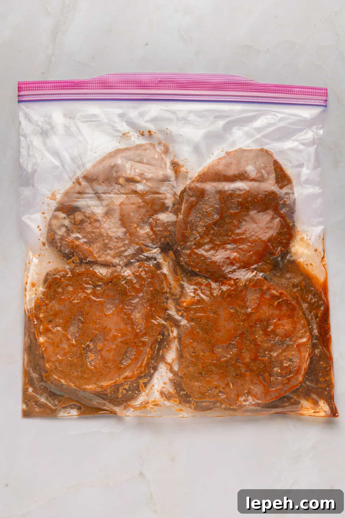 Marinated pork chops in a ziplock bag.