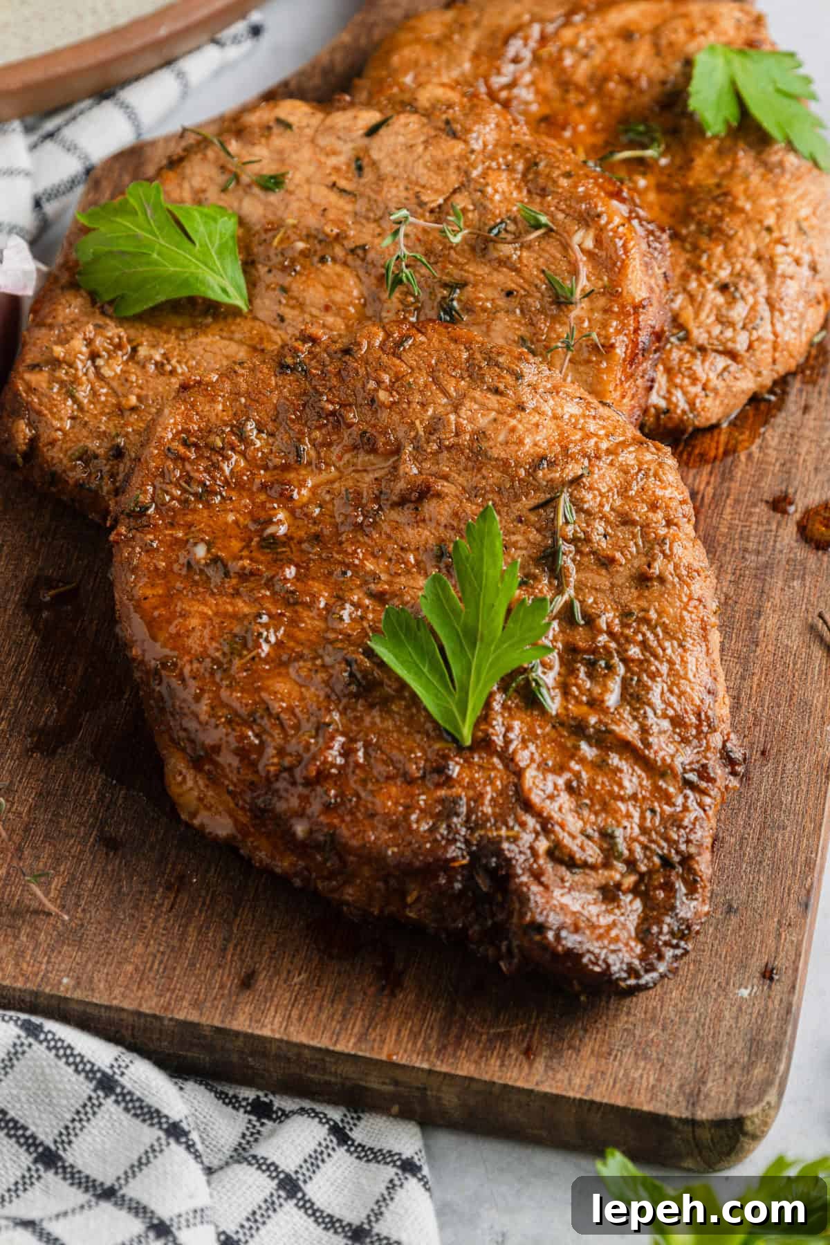 Air fryer pork chops on a cutting board.