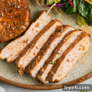 Air fryer honey garlic pork chops sliced on a plate.