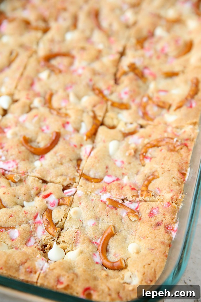 A partial picture of a glass 9x13 dish with cut white chocolate peppermint pretzel cookie bars.
