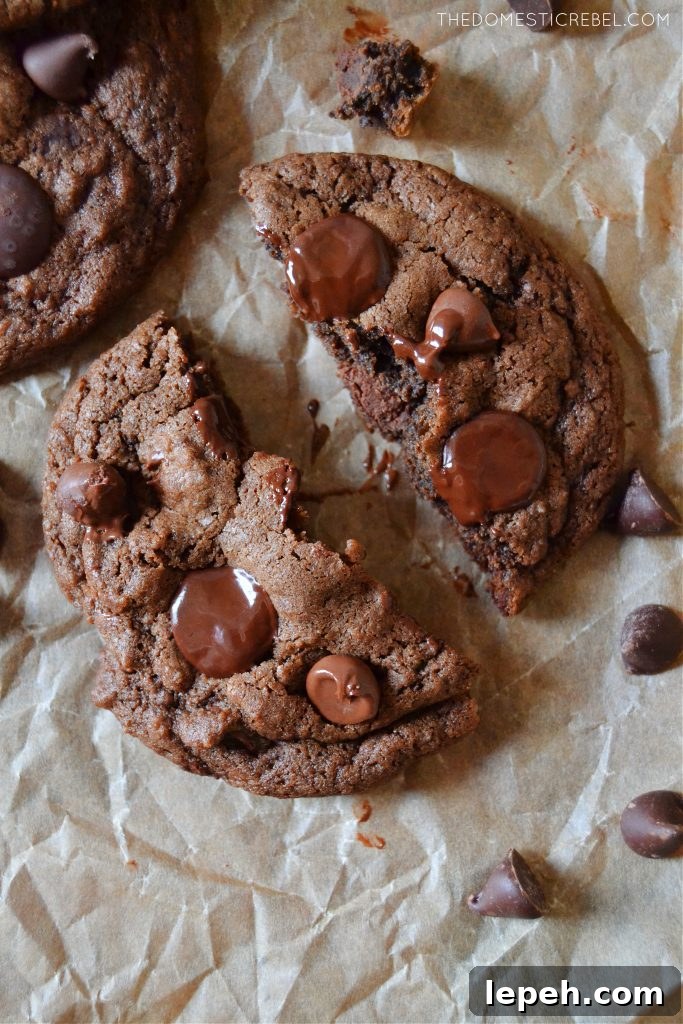 a chocolate chocolate chip cookie split open on parchment