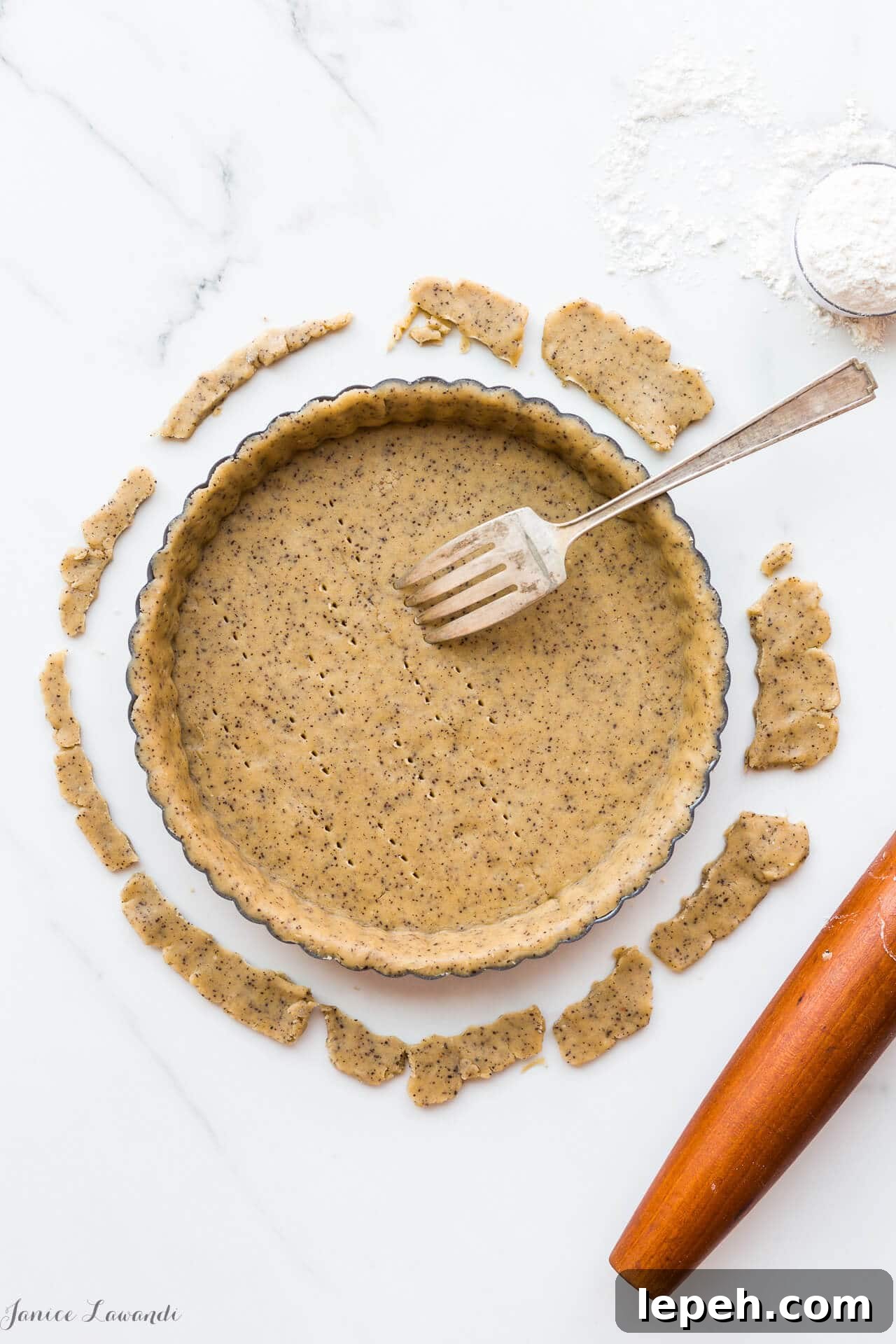 Coffee sablé cookie crust - the raw crust is being docked (pricked) with a fork to allow steam/air to vent during baking. The crust will be blind baked