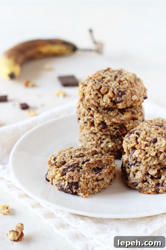 A plate with several Banana Breakfast Cookies stacked on top of each other.