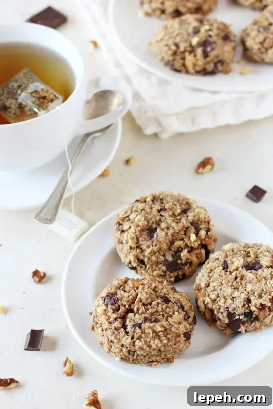 A white plate with three Banana Oat Breakfast Cookies with more cookies in the background.