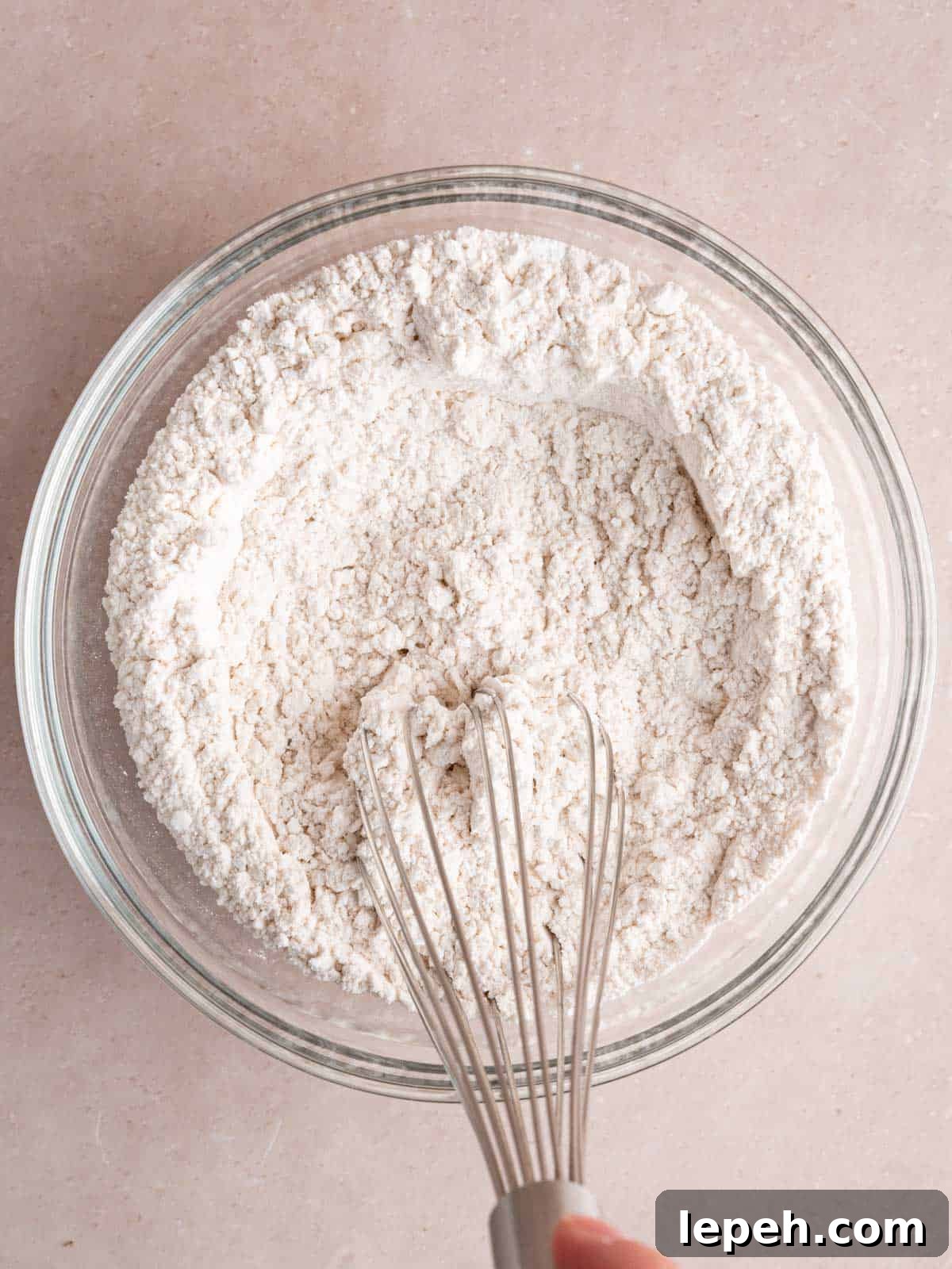 Whisking flour, baking powder, baking soda, and salt in a bowl.