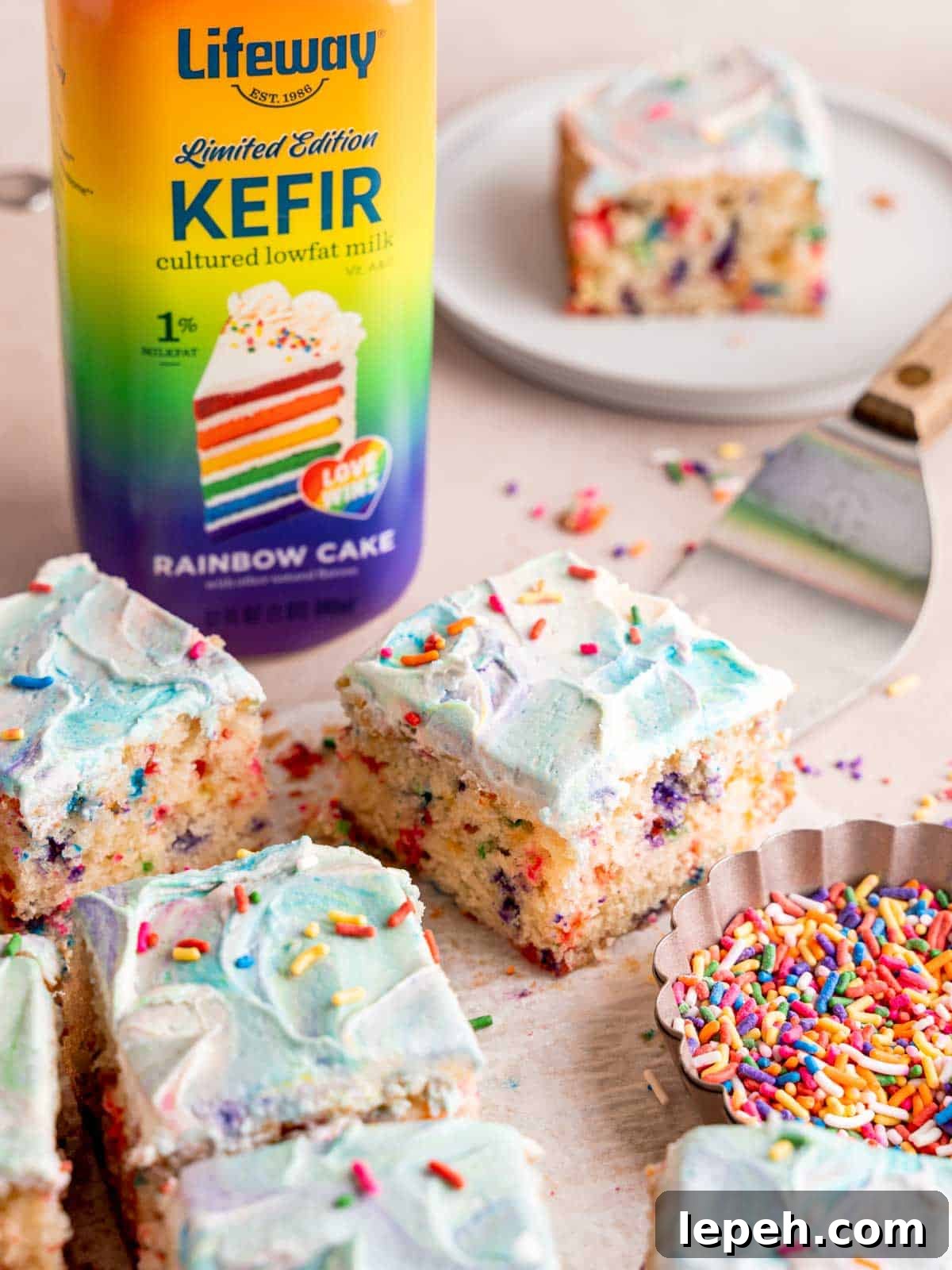 Slices of a rainbow snack cake next to a bottle of Lifeway kefir.