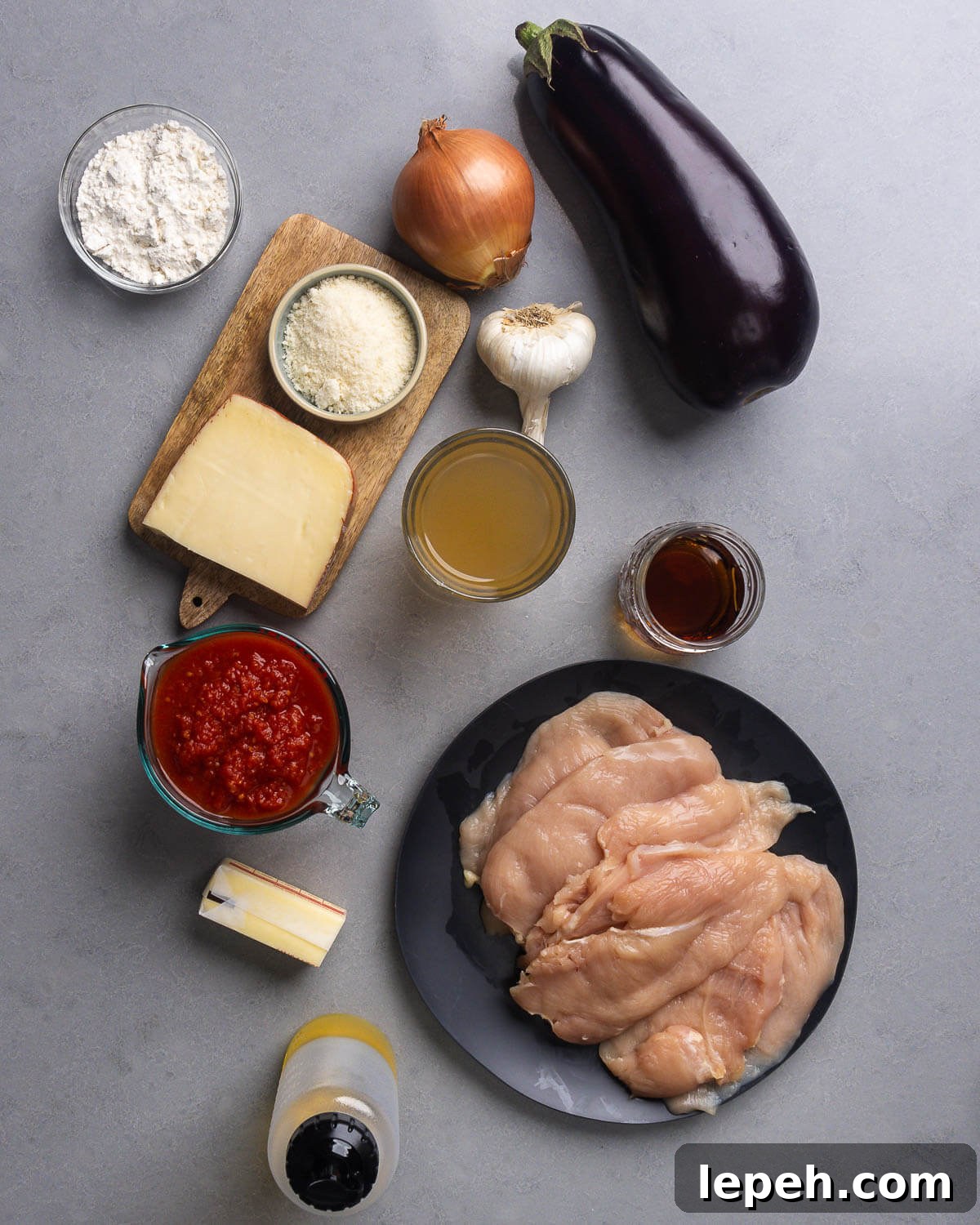 Ingredients shown: flour, fontina cheese, parmesan, onion, eggplant, garlic, chicken stock, marsala wine, plum tomatoes, butter, chicken breasts, and olive oil.