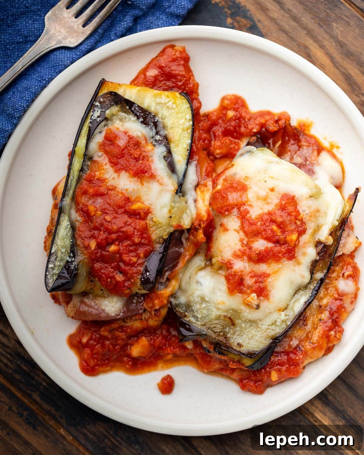 Two pieces of chicken sorrentino on white plate