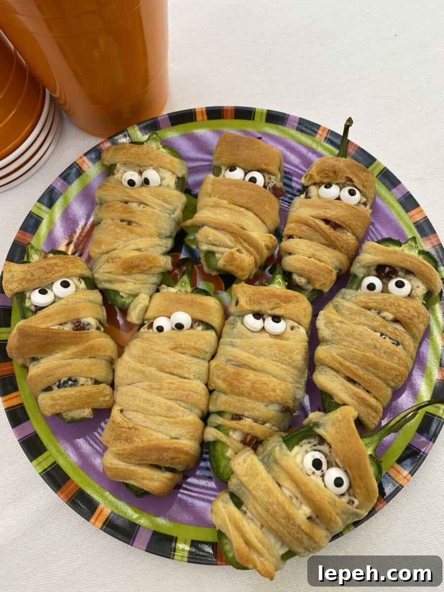 A plate with eight wrapped jalapeño bacon mummies wrapped in dough.
