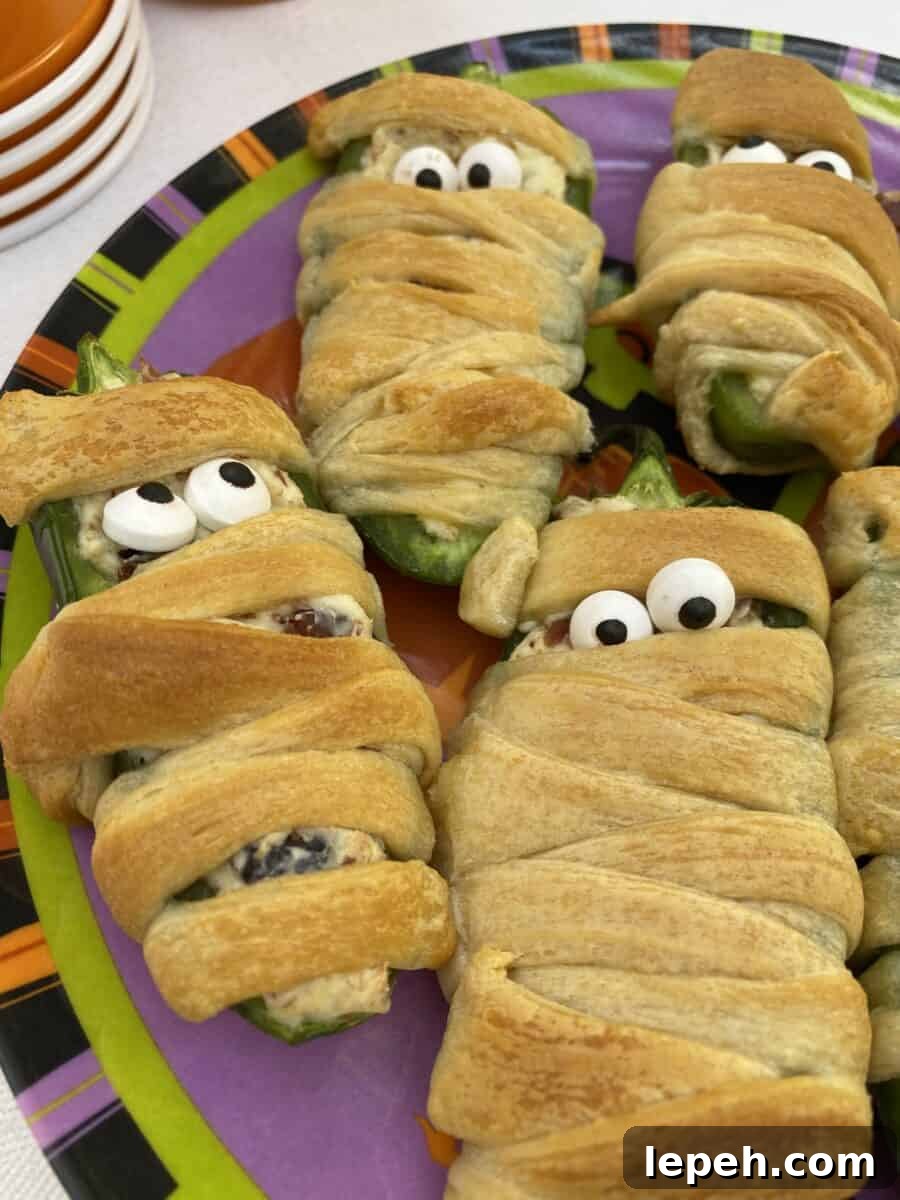 Jalapeño popper wrapped with dough and displaying candy eyes.
