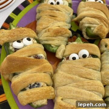 Jalapeño popper wrapped with dough and displaying candy eyes.