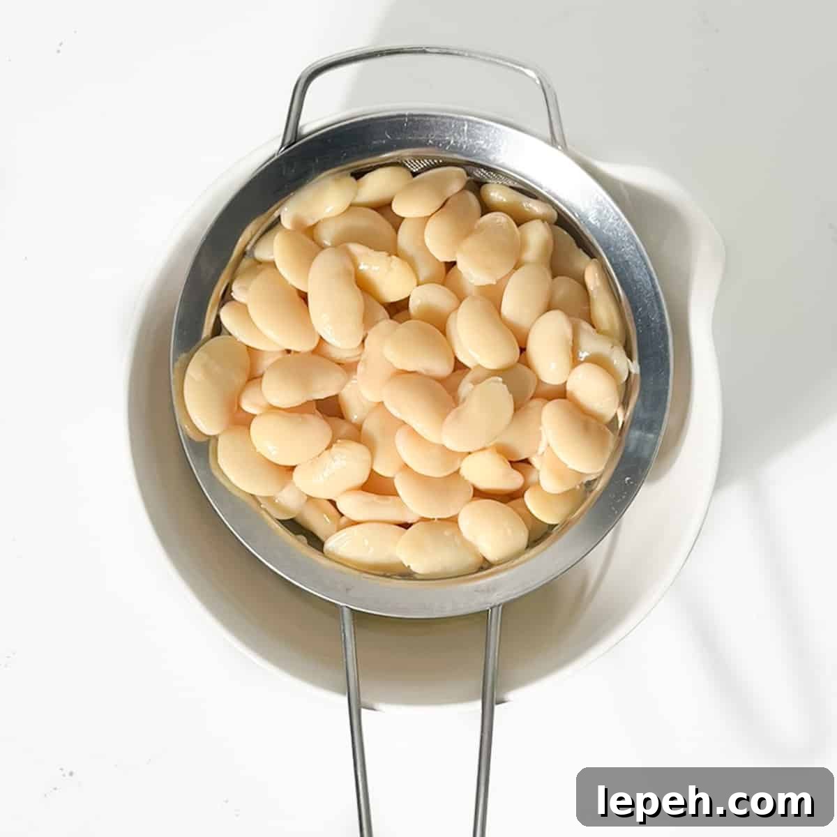 Draining the butter beans in a sieve for the butter bean curry.