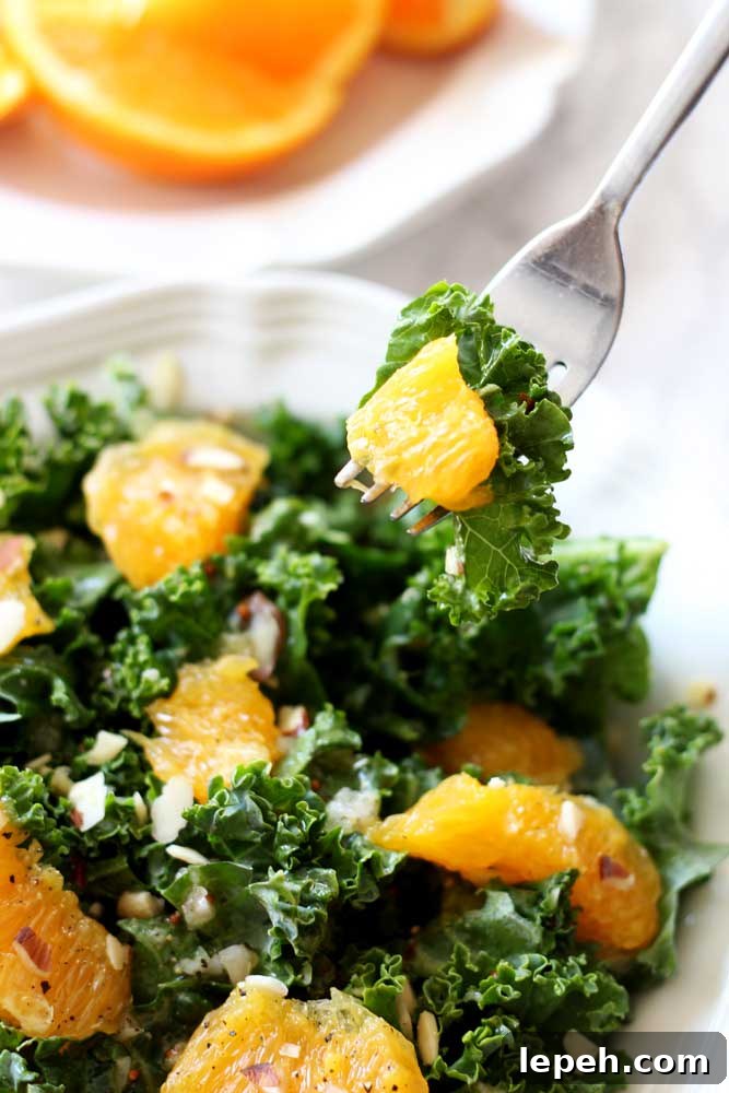 A plate of orange and kale salad on a fork