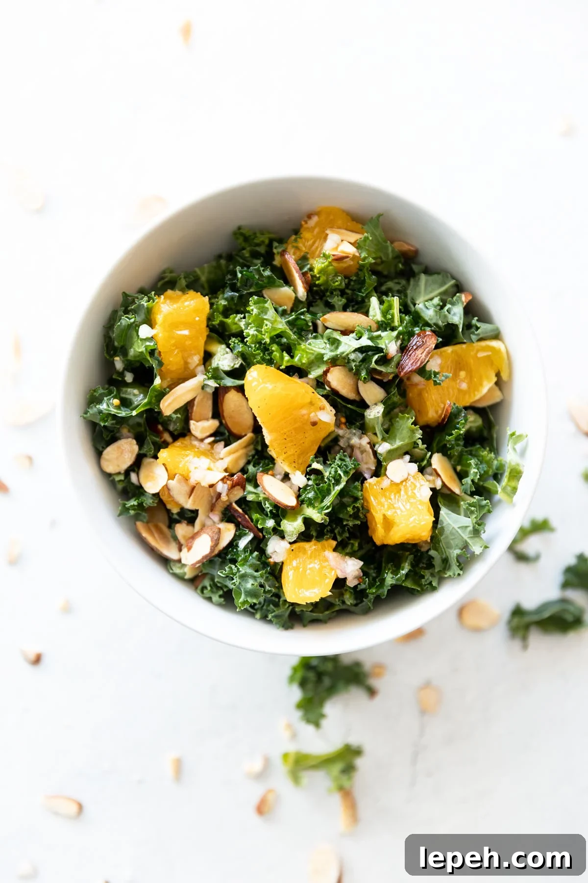 Kale salad topped with oranges, almonds, and citrus vinaigrette dressing.