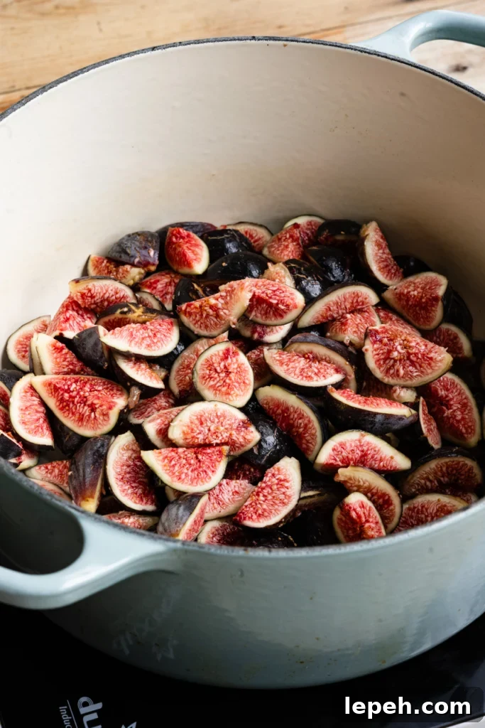 Large cooking pot filled with sliced figs.