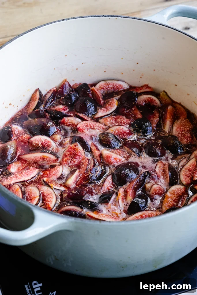 Large pot filled with figs and sugar boiling.