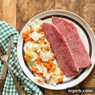 Corned Beef and Cabbage on brown plate with green napkin