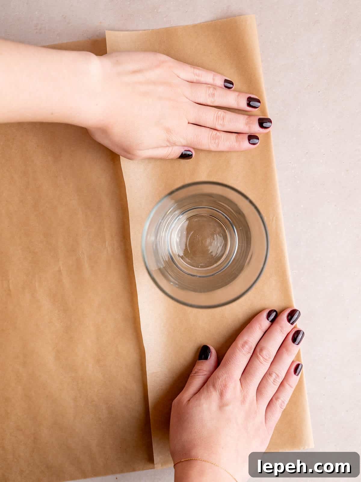 A pint glass sitting on top of a folded piece of parchment paper.