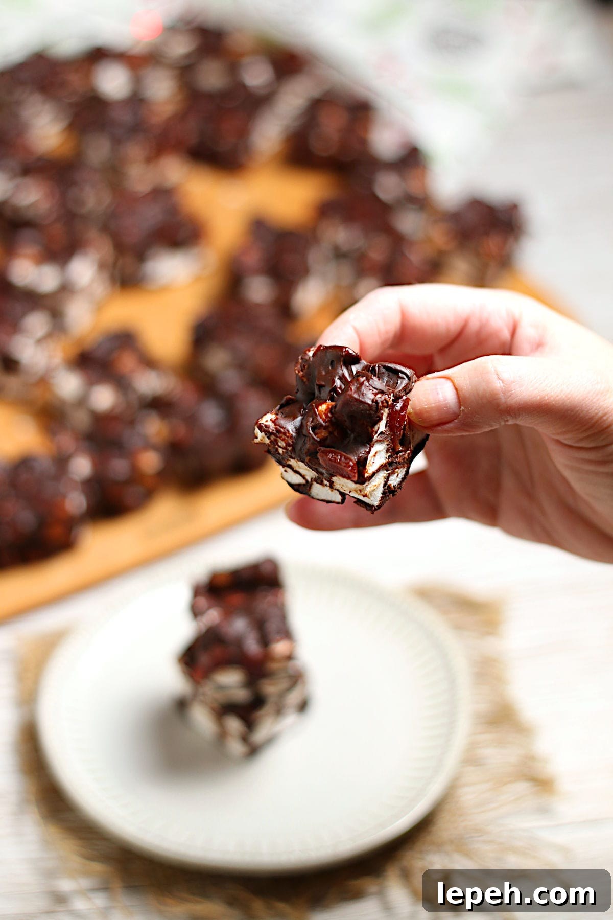 A hand holding a Chocolate Cherry Marshmallow Square.