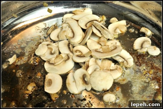 Sliced mushrooms are cooked in bacon drippings in skillet.