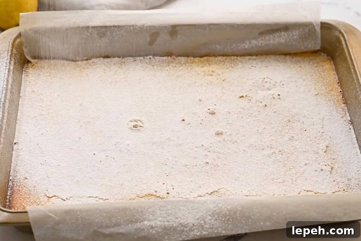 dusting baked lemon bars with powdered sugar.