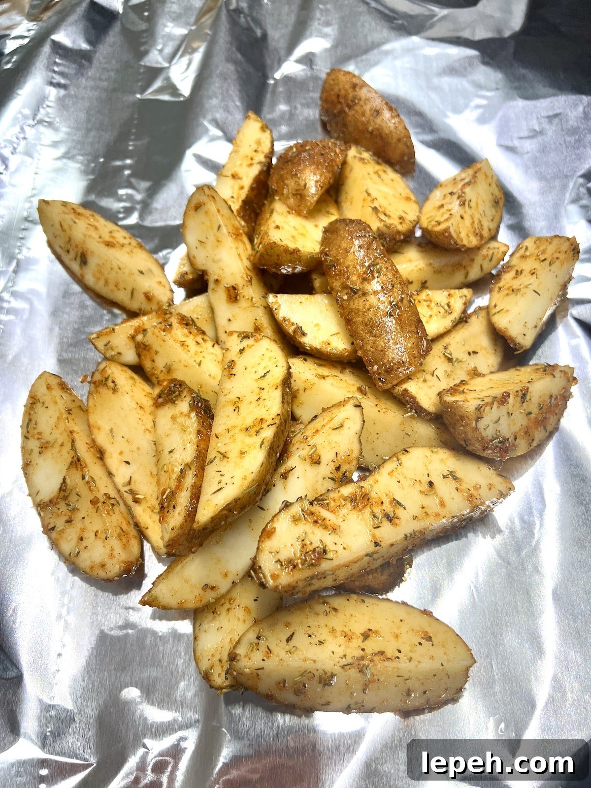 Potato wedges on aluminum foil.